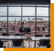 student at table by large windows